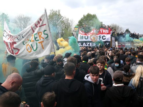 Smoke flares are let off outside Old Trafford as fans protest against the Glazers (Barrington Coombs/PA)