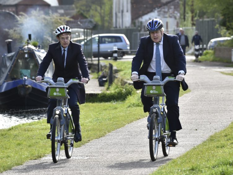 Boris Johnson and mayor for West Midlands Andy Street ride bikes along the towpath of the Stourbridge canal (Rui Vieira/PA)