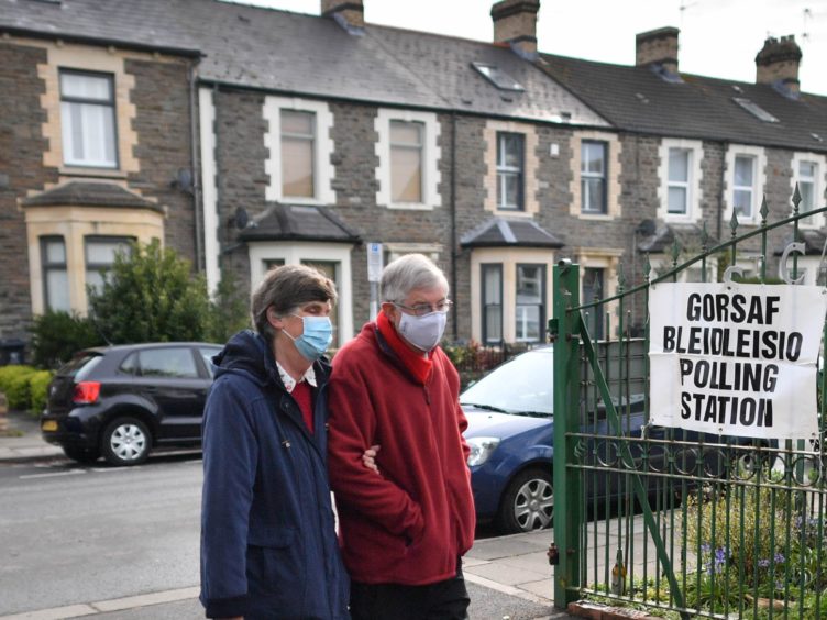 First Minister Mark Drakeford and his wife, Clare Drakeford, arriving at St Catherine’s church hall polling station to cast their votes (PA)