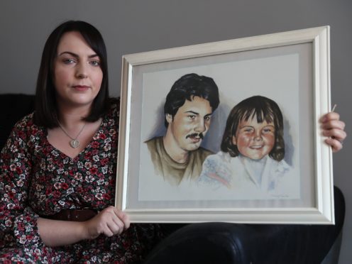 Charlene Smyth, holds a painting of herself with her father Charlie McGrillen, who was killed by the UFF in 1988 (Brian Lawless/PA)