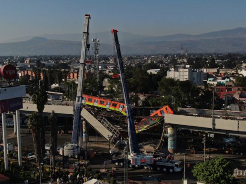 Subway cars dangle at an angle from a collapsed elevated section of the metro, in Mexico City, Tuesday, May 4, 2021. The elevated section of the metro’s Line 12 collapsed late Monday killing at least 23 people and injuring at least 79, city officials said. (AP Photo/Fernando Llano)