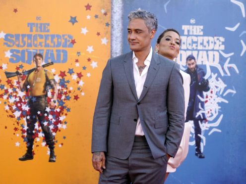 Taika Waititi, left, a cast member in “The Suicide Squad,” is joined by his date, singer Rita Ora, as he poses at the premiere of the film at the Regency Village Theatre, Monday, Aug. 2, 2021, in Los Angeles. (AP Photo/Chris Pizzello)