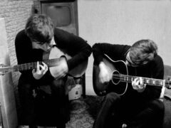 Sir Paul McCartney and John Lennon playing guitar together (British Library/PA)