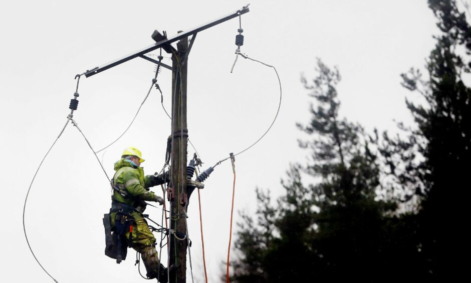 Electricity worker up pole fixing damage from storm