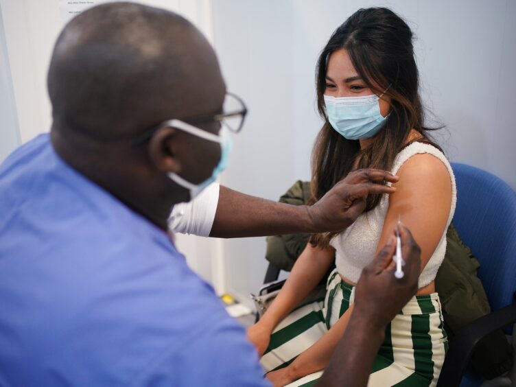 Kyna Bigornia receives her Pfizer Covid-19 booster injection at a vaccination site in Liberty Shopping Centre, Romford, east London, as the Government accelerates the Covid booster programme to help slow down the spread of the new Omicron variant (Yui Mok/PA)