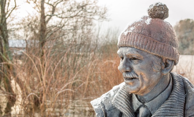 A snowy Tom Weir statue looks across Loch Lomond. Photo by Paul Saunders Photography