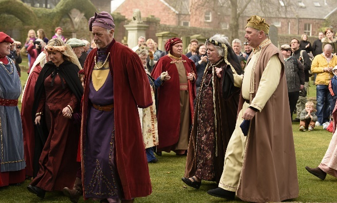 Members of King Robert Bruce's Royal Court file out of Arbroath Abbey