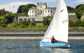 A Kestrel class of boat passing the clubhouse