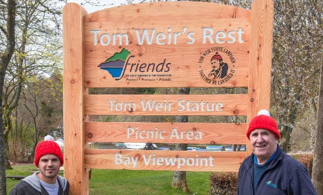 Stuart Fraser of the Oak Tree Inn and James Fraser, chair of the Friends of Loch Lomond & The Trossachs next to the Tom Weir's Rest sign