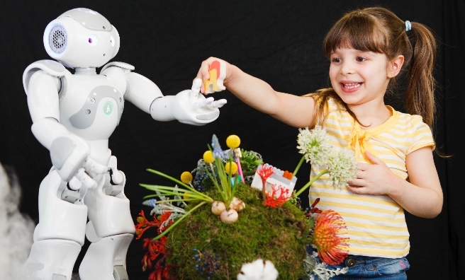 Gabriella Nombro (4) and (Baxter the Big one and Now the wee one) the robot play at the launch of Edinburgh International Science Festival's 28th Festival programme – Building Better Worlds. Photo by Toby Williams