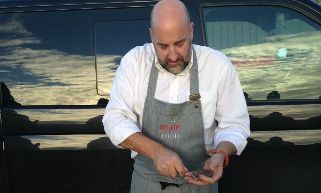 Monachyle Mhor's renowned chef, Tom Lewis, prepares oysters on the banks of a loch in Galloway Forest