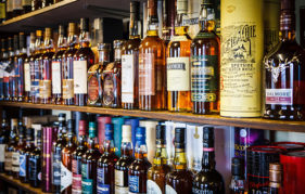 Whisky pronunciation guid. Image features a massive stock of whisky brands all shelved behind a bar.