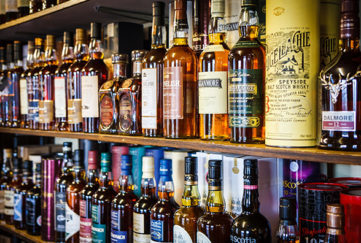 Whisky pronunciation guid. Image features a massive stock of whisky brands all shelved behind a bar.