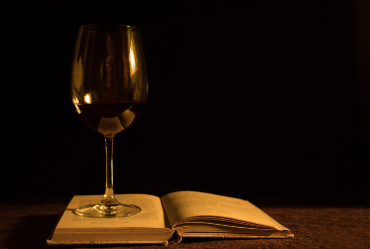 A wine glass and a book
