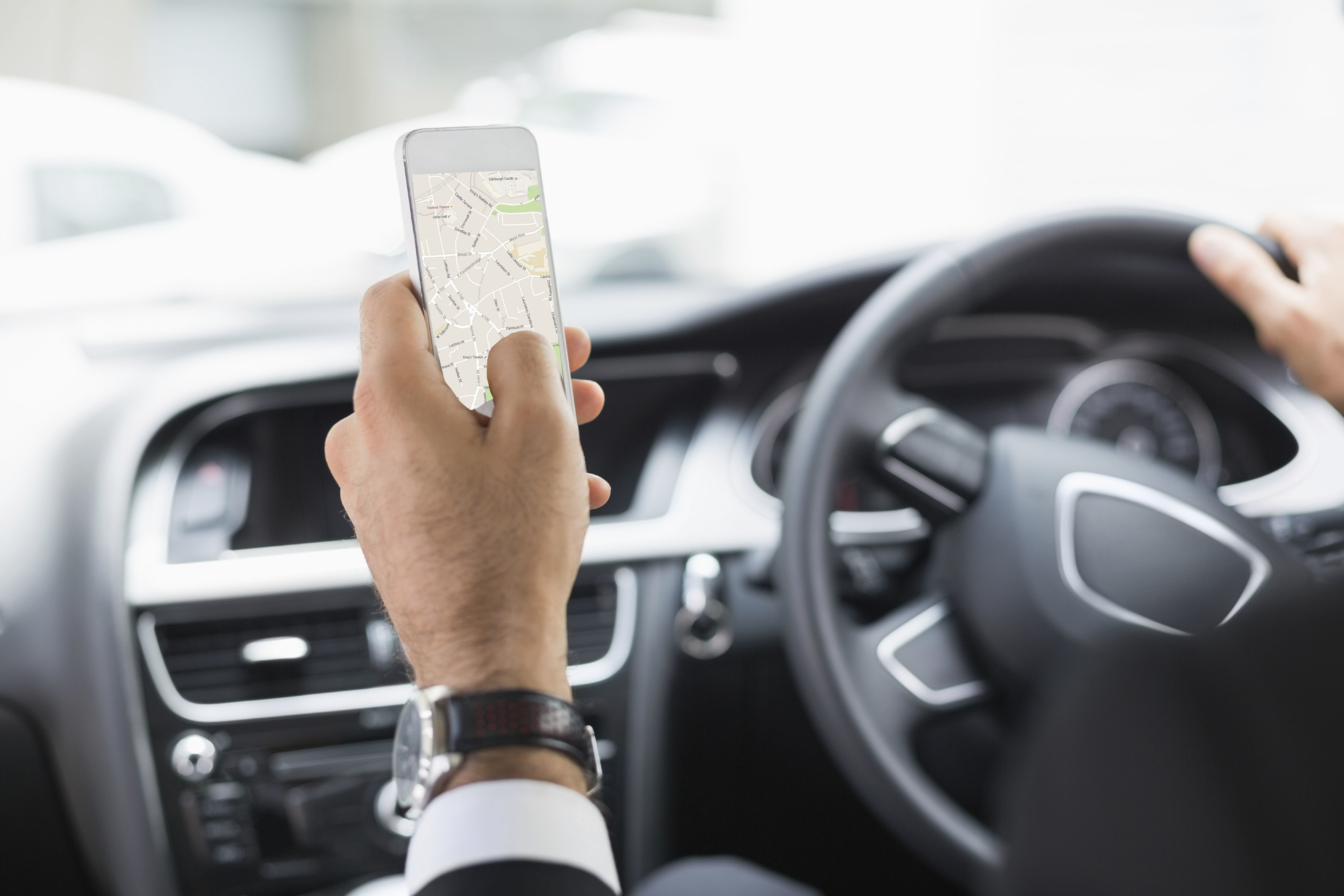 Man holding smartphone while driving