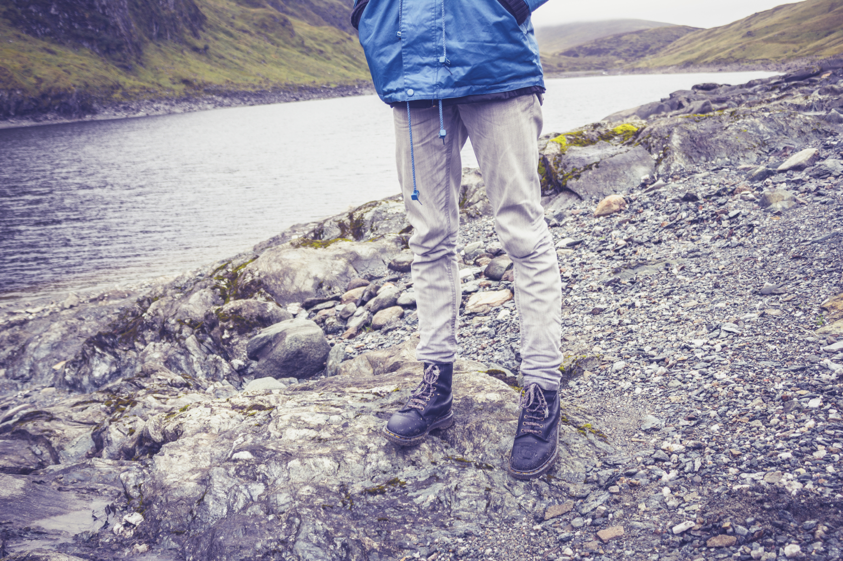 Close up on hillwalkers feet and legs by water to illustrate walks in Scotland
