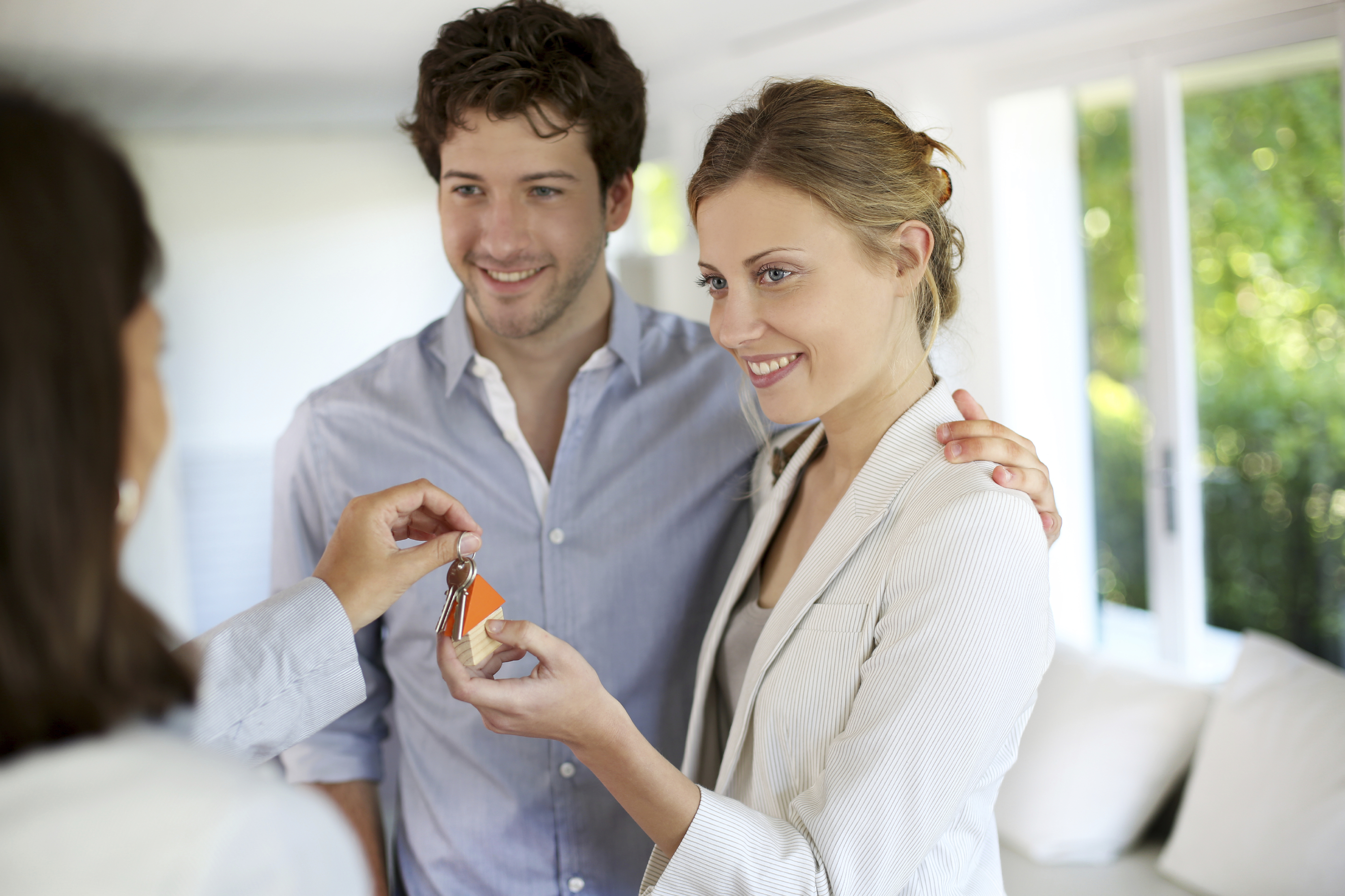 Happy young couple getting keys of their new home