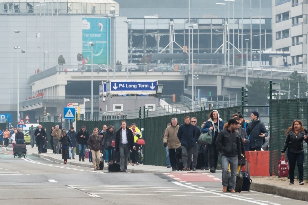 People walk away from Brussels airport (AP Photo/Geert Vanden Wijngaert)