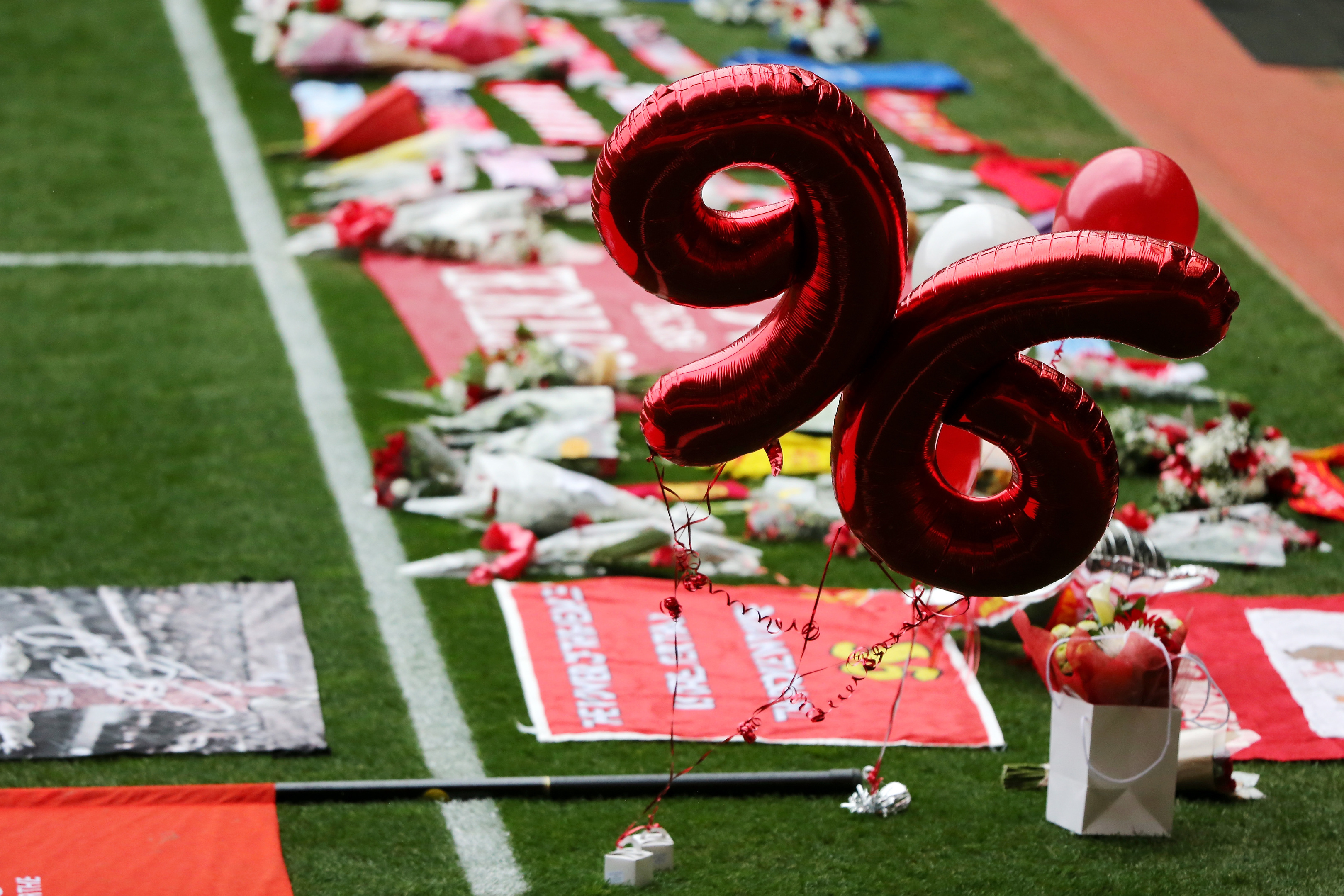 Tributes are placed on the pitch before the memorial service (Christopher Furlong/Getty Images)