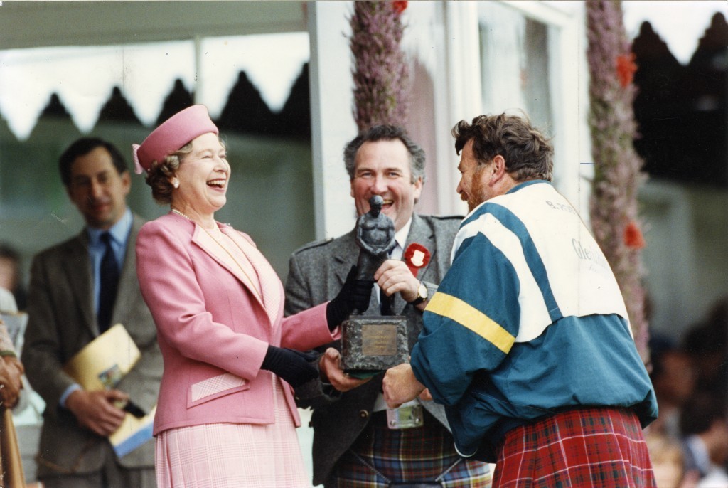 The Queen laughs as she presents Braemar caber champ Brian Robin with his trophy (DC Thomson)