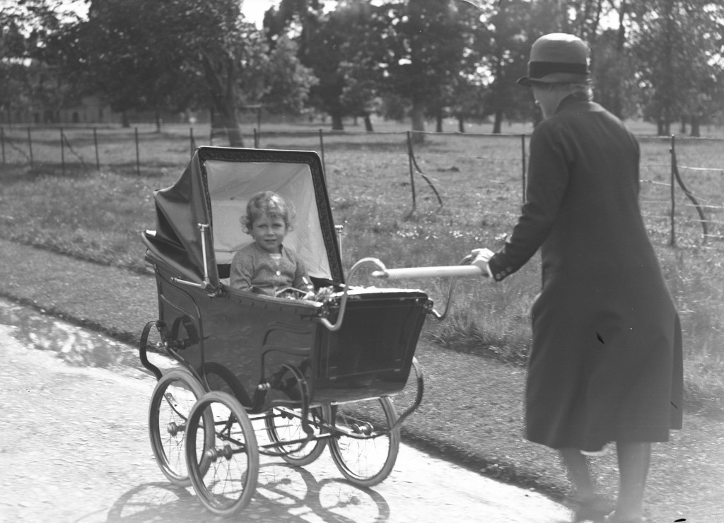 Princess Elizabeth sits up as she is pushed in a pram by an unknown woman in the grounds of Glamis (DC Thomson)