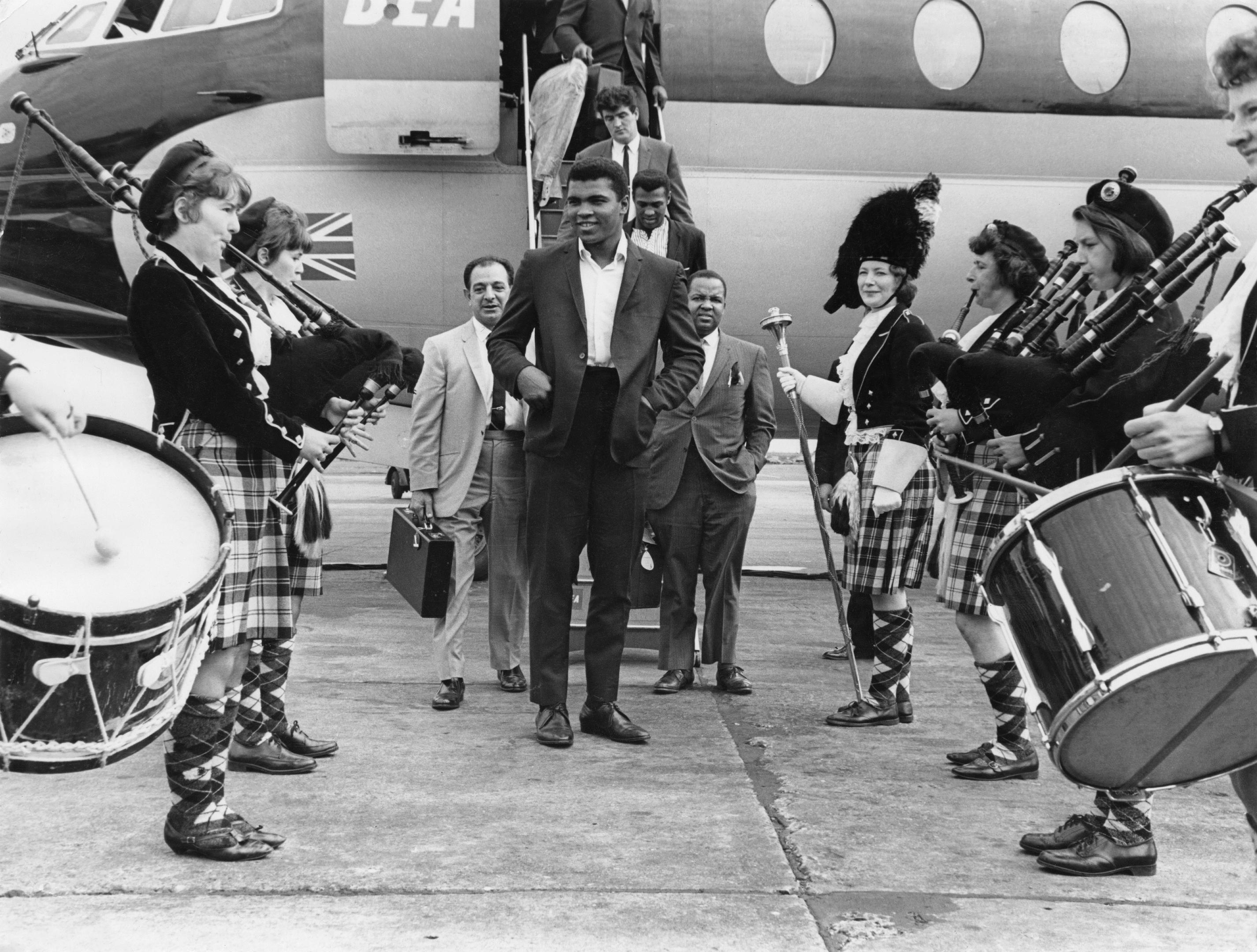 Muhammad Ali is greeted by a traditional Scottish pipe band on his arrival at Glasgow Airport, 18th August 1965 (Daily Express/Pictorial Parade/Archive Photos/Getty Images)
