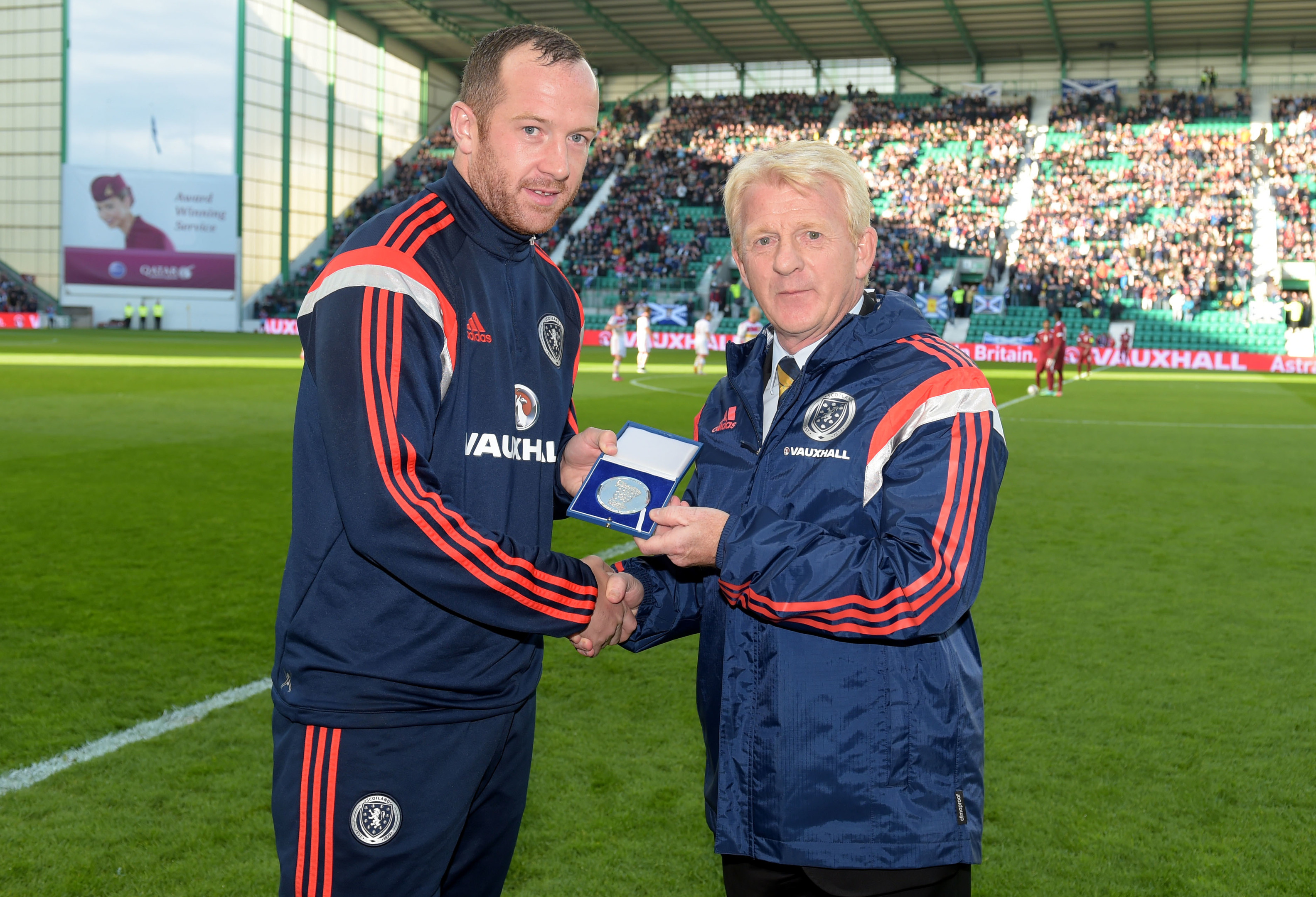 Scotland midfielder Charlie Adam is presented with a gift for reaching 25 caps by manager Gordon Strachan (right) (SNS Group)