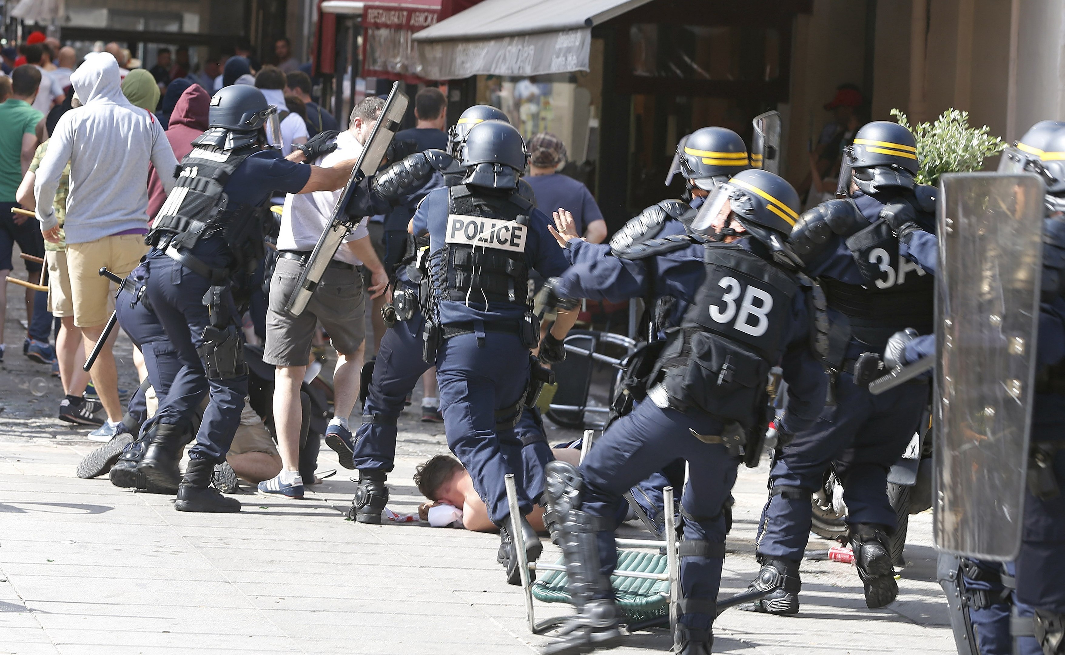 French police officers charge soccer supporters during clashes in downtown Marseille, France (AP Photo/Darko Bandic)