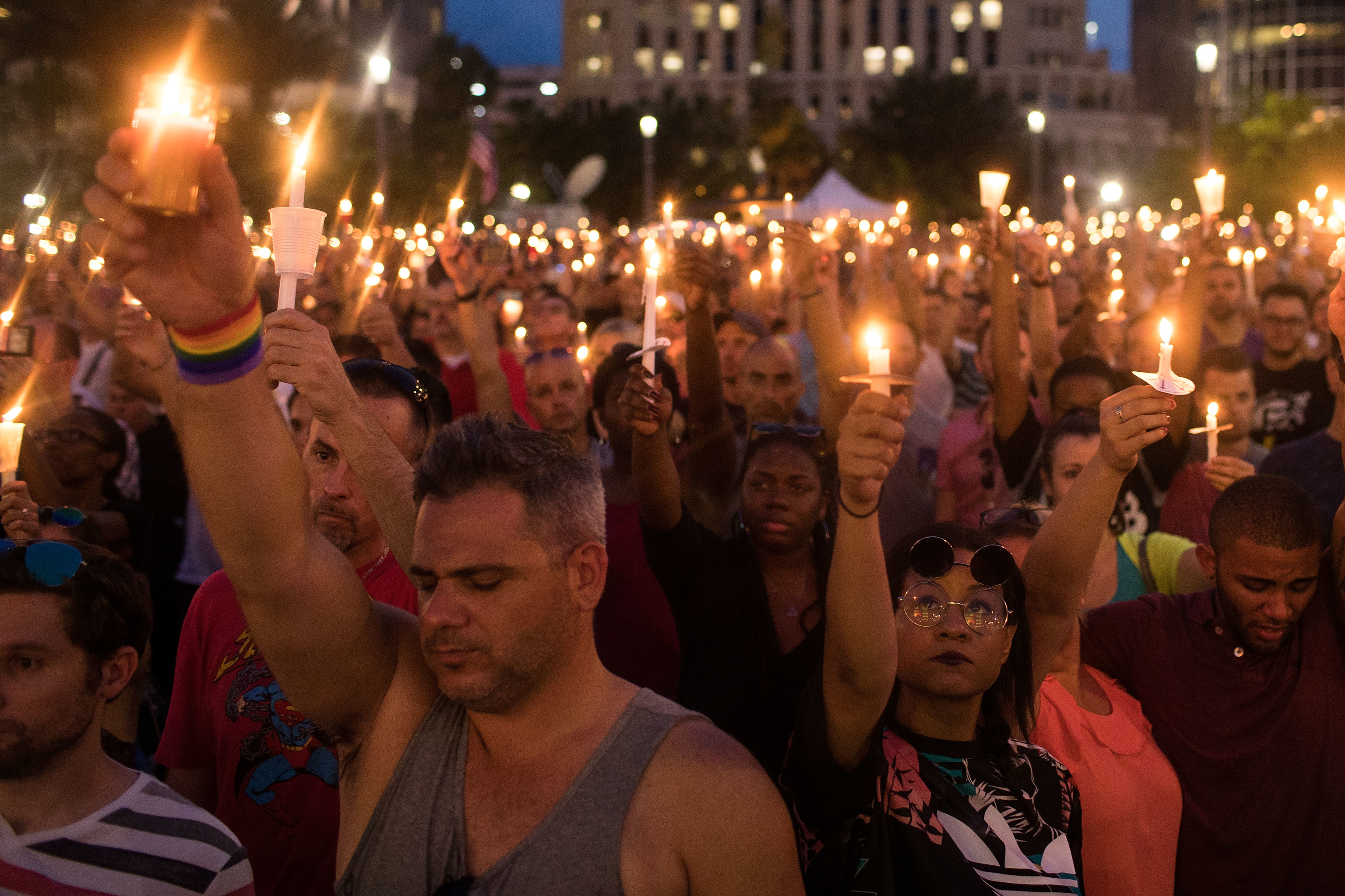 People hold candles during an evening memorial service for the victims of the Pulse Nightclub shootings, at the Dr. Phillips Center for the Performing Arts in Orlando, Florida (Drew Angerer/Getty Images)