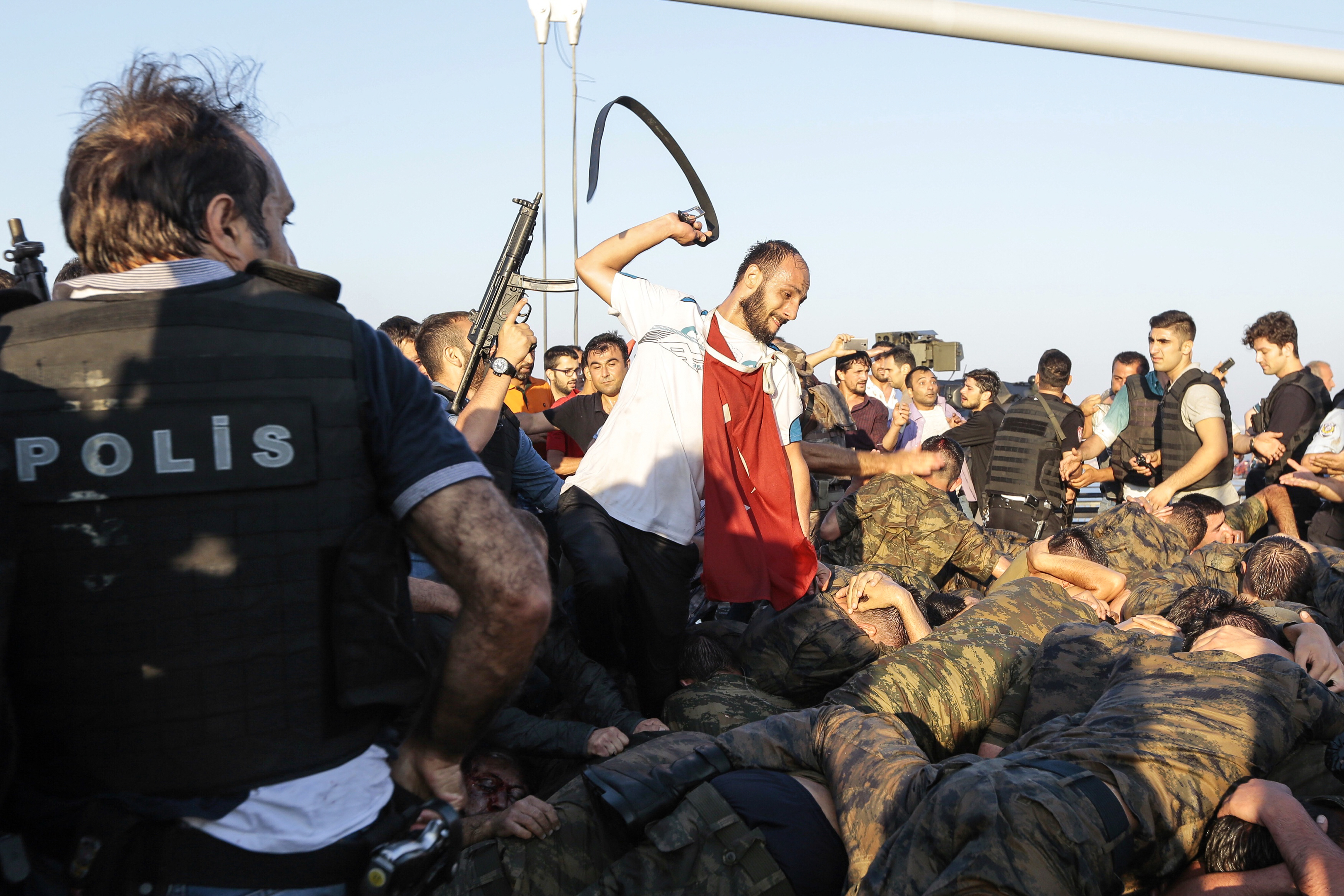 An unidentified man uses his belt to hit Turkish soldiers involved in the coup attempt that have now surrendered (Gokhan Tan/Getty Images)