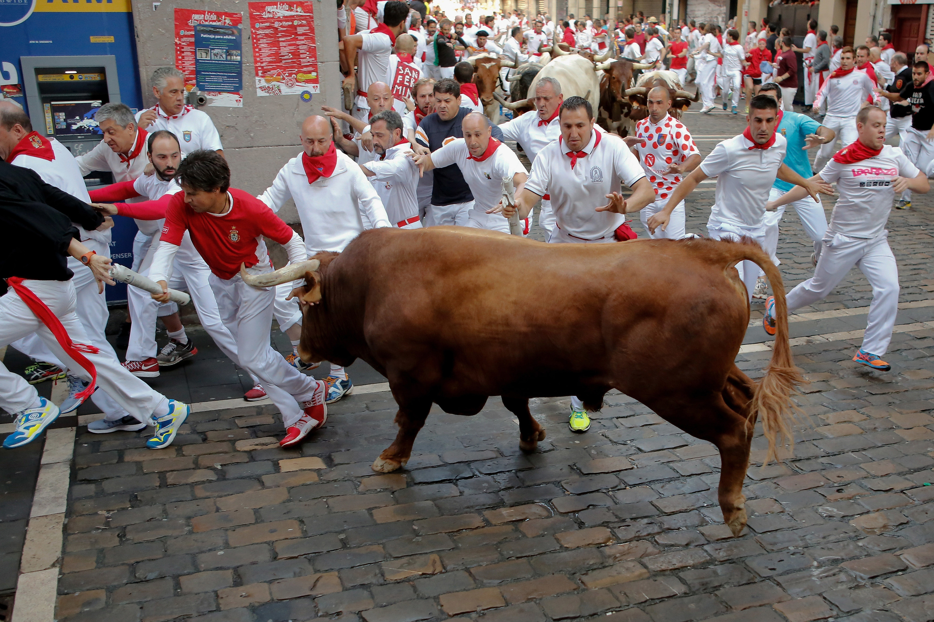 Revellers run with Cebada Gago's fighting bulls entering Estafeta Street as a bull charge over runners during the third day of the San Fermin Running of the Bulls festival (Pablo Blazquez Dominguez/Getty Images)