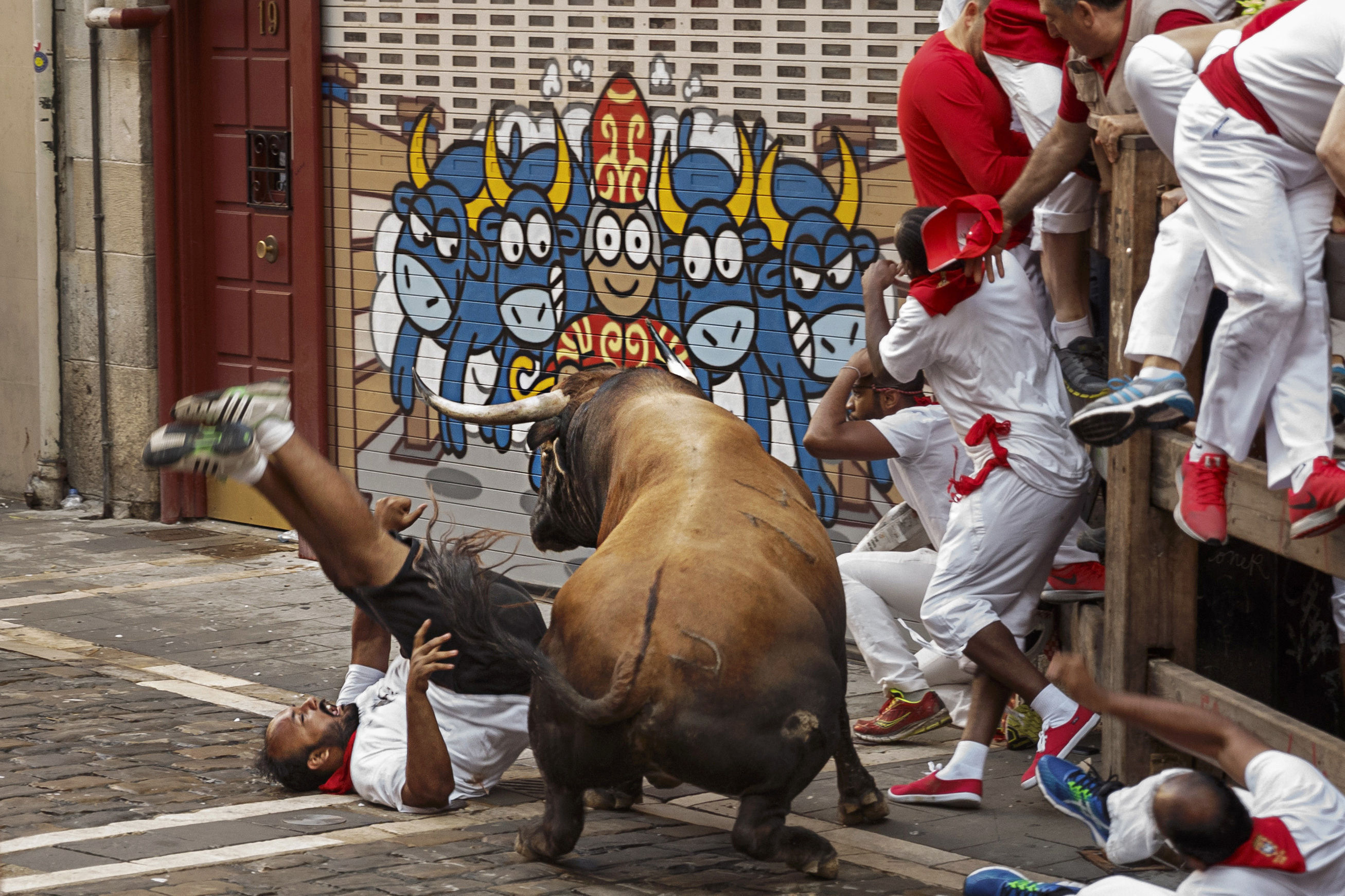 A reveller is gored by a Cebada Gago's ranch fighting bull during the running of the bulls in Pamplona, Spain (AP Photo/Daniel Ochoa de Olza)