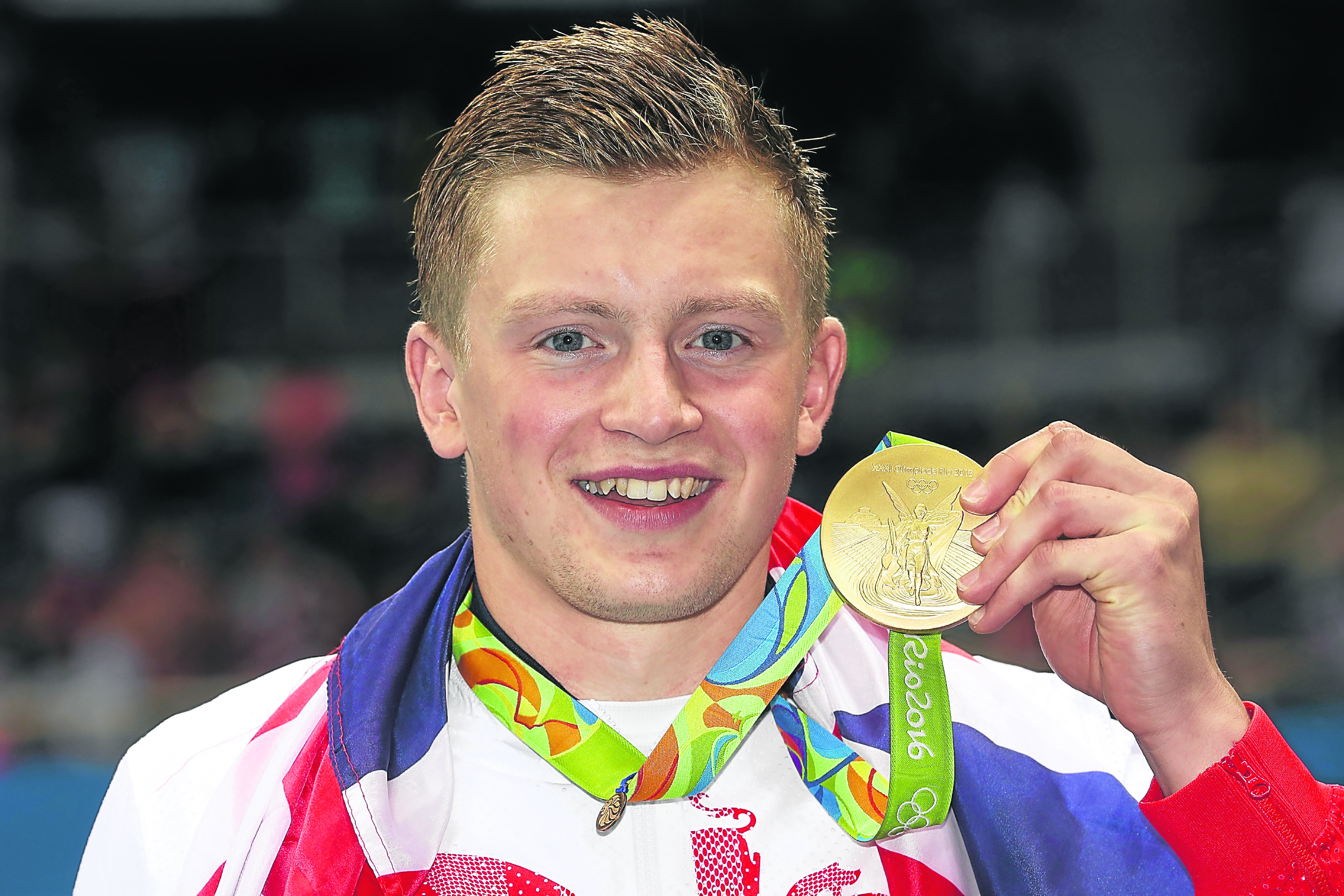 Gold medallist Adam Peaty of Great Britain poses during the medal ceremony for the Men's 100m Breaststroke Final (Photo by Julian Finney/Getty Images)