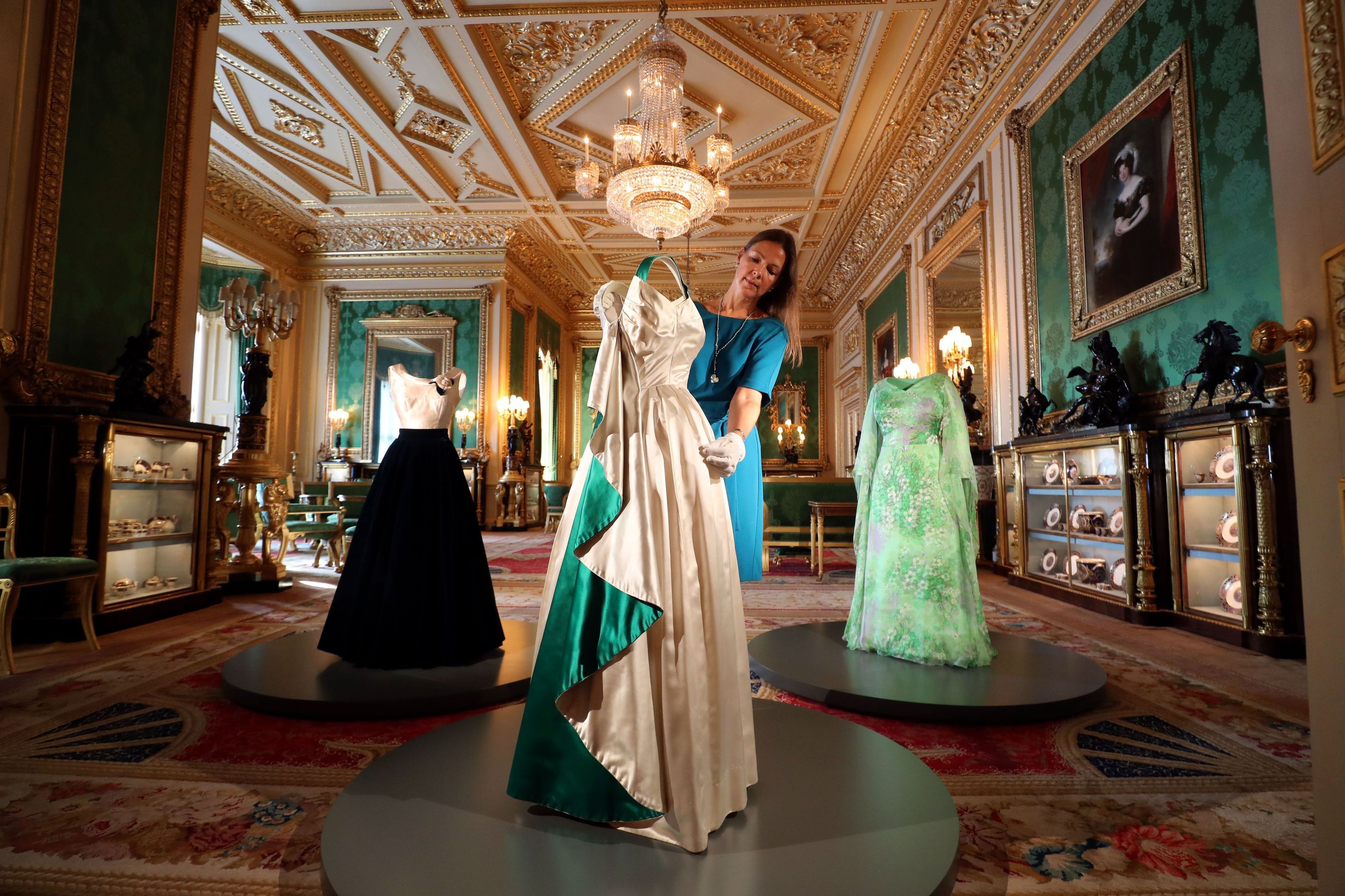 Curator Caroline de Guitaut arranges an evening gown worn by The Queen, in the Green Drawing Room (Steve Parsons/PA Wire)