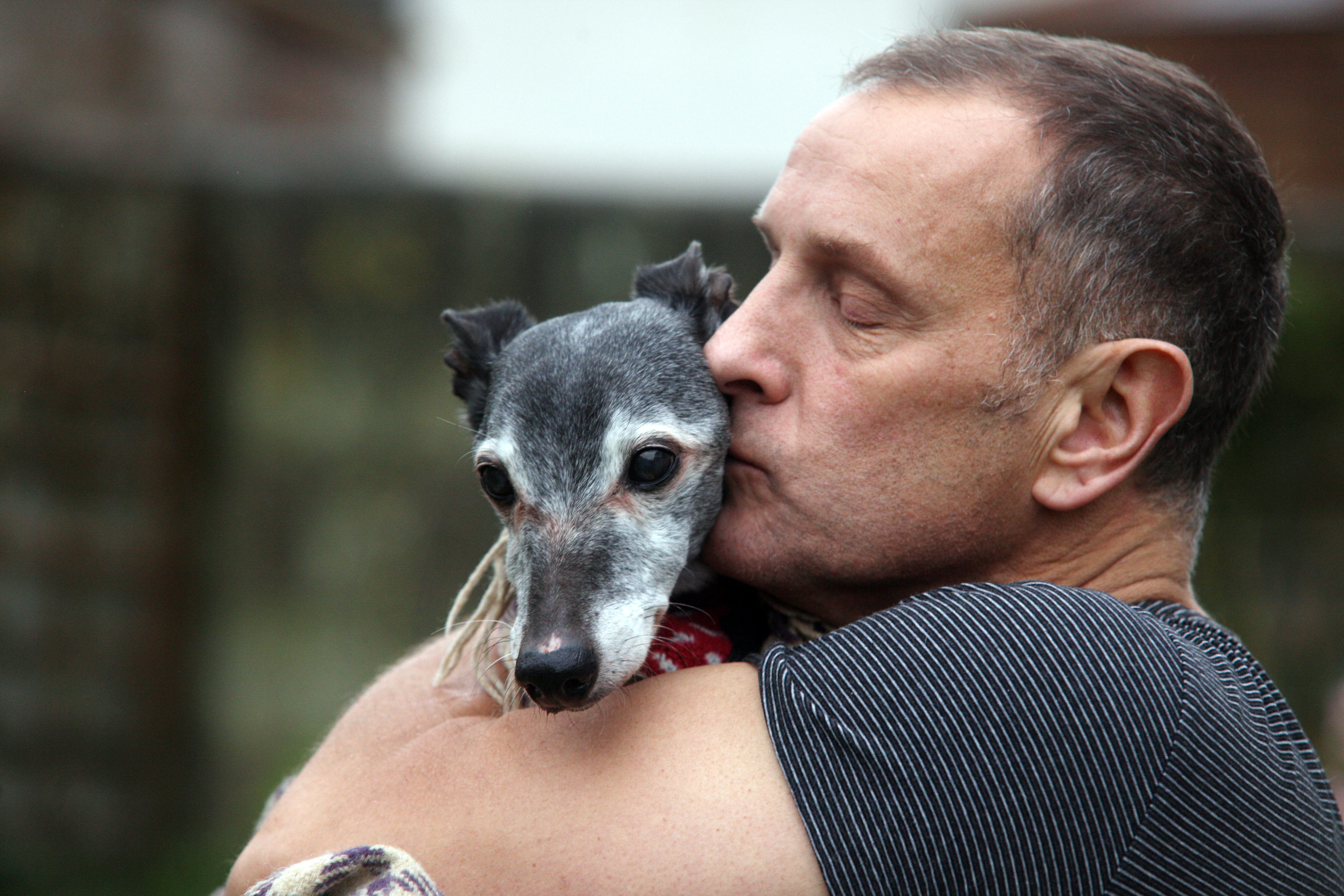 Mark Woods kisses his dog Walnut before taking him to Porth beach for a final walk (SWNS / Neil Hope)