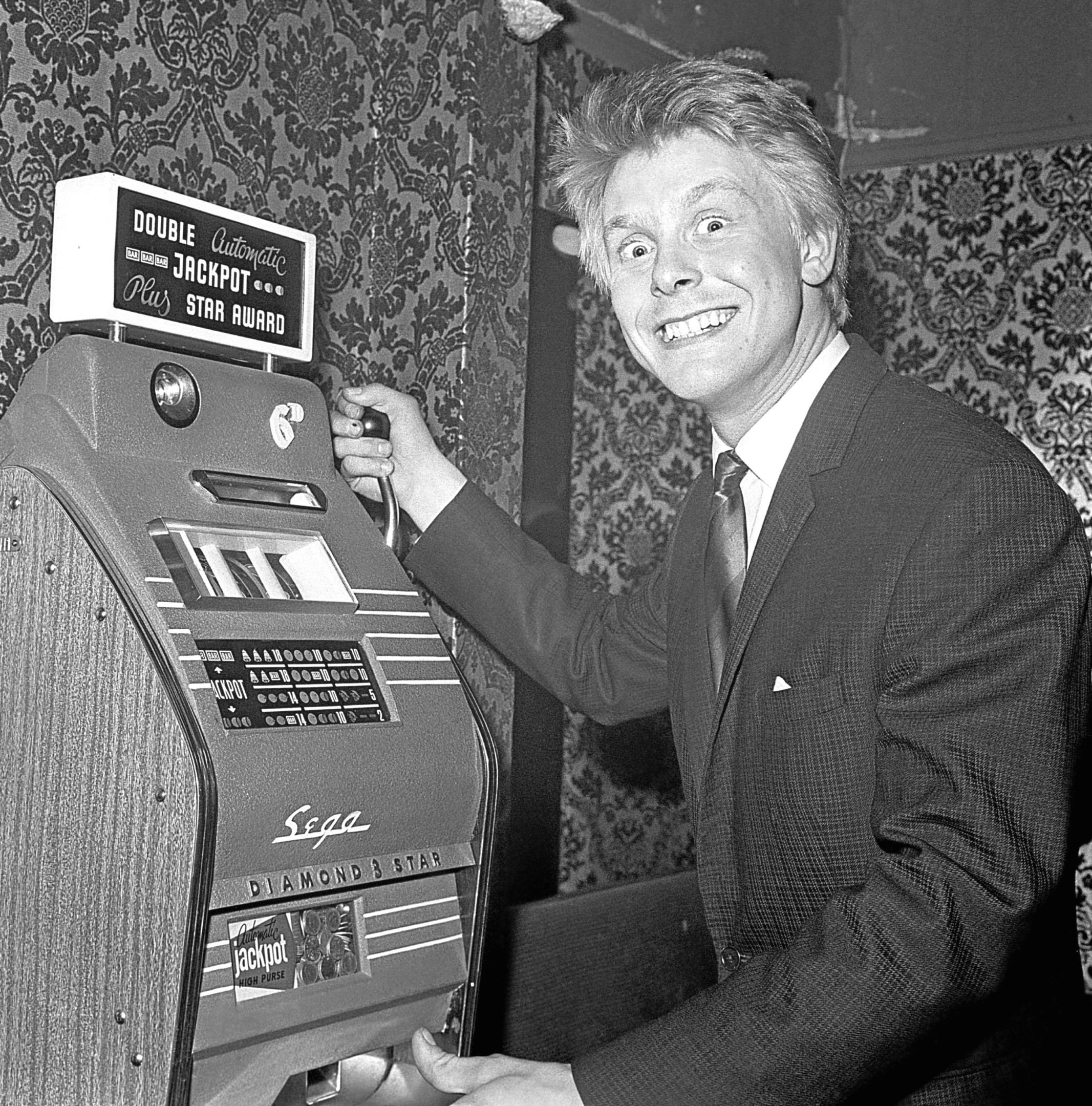 Joe Brown - he's the 'pop' star with the Bruvvers - who signed as the star of a new 70,000 west end musical, celebrates with a go on a one armed bandit at the Masquerade Club, Romilly St.