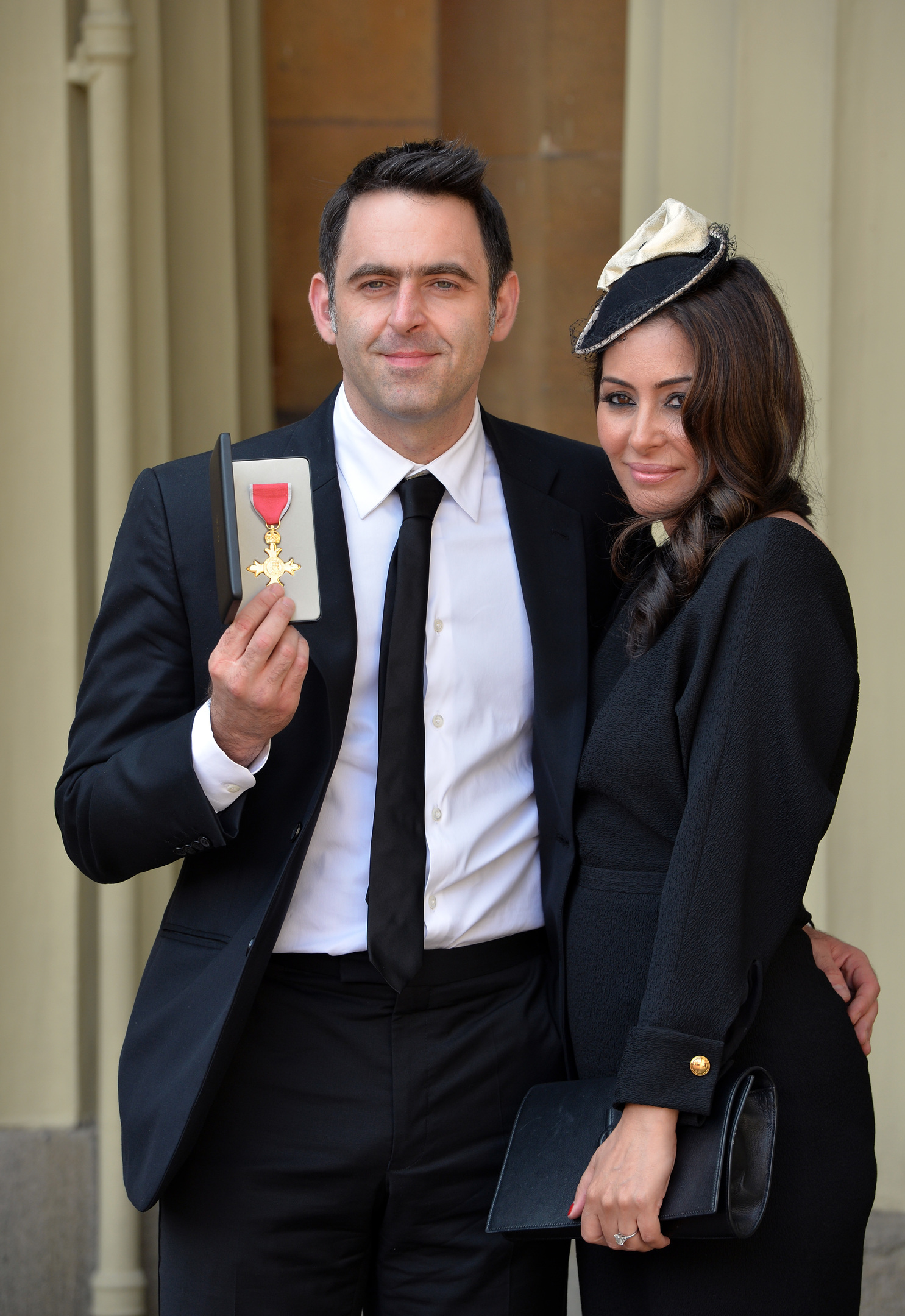 Snooker player Ronnie O'Sullivan poses with his partner Laila Rouass after receiving an OBE from the Prince of Wales at an investiture ceremony (Photos by John Stillwell - WPA Pool/Getty Images)