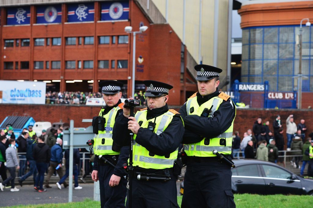 Police officers film supporters' arrival at the stadium (Mark Runnacles/Getty Images)
