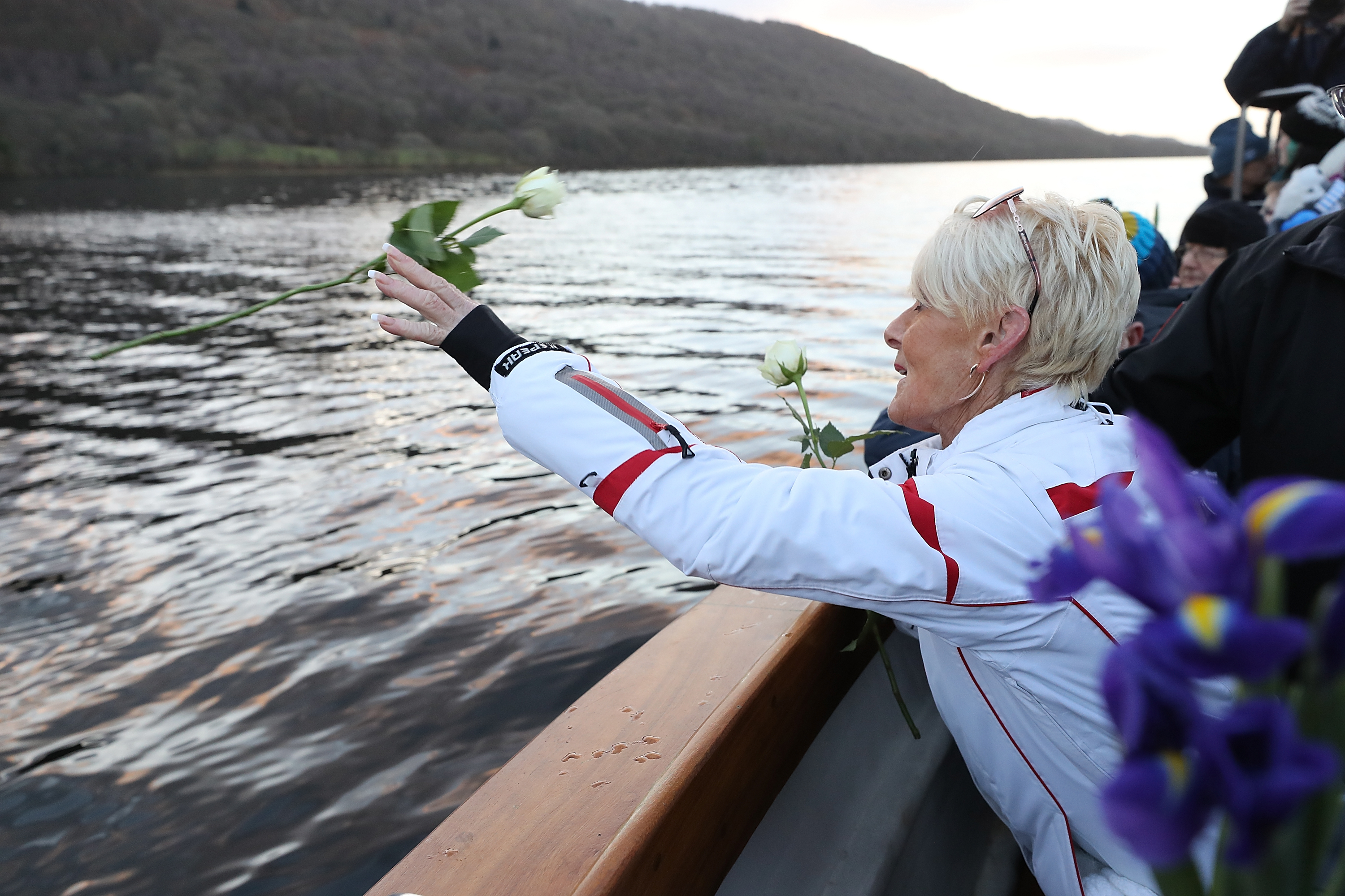 Gina Campbell throws flowers near the site of the fatal crash of the Bluebird boat on Coniston Water  (Getty Images)
