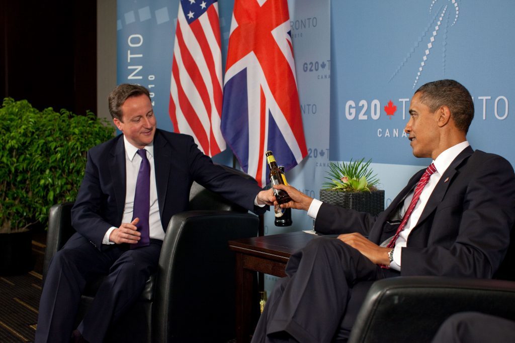 President Barack Obama and British Prime Minister David Cameron trade bottles of beer to settle a bet they made on the U.S. vs. United Kingdon World Cup Soccer game, during a bilateral meeting at the G20 Summit in Toronto, Canada, Saturday, June 26, 2010. (Official White House Photo by Pete Souza) This official White House photograph is being made available only for publication by news organizations and/or for personal use printing by the subject(s) of the photograph. The photograph may not be manipulated in any way and may not be used in commercial or political materials, advertisements, emails, products, promotions that in any way suggests approval or endorsement of the President, the First Family, or the White House.