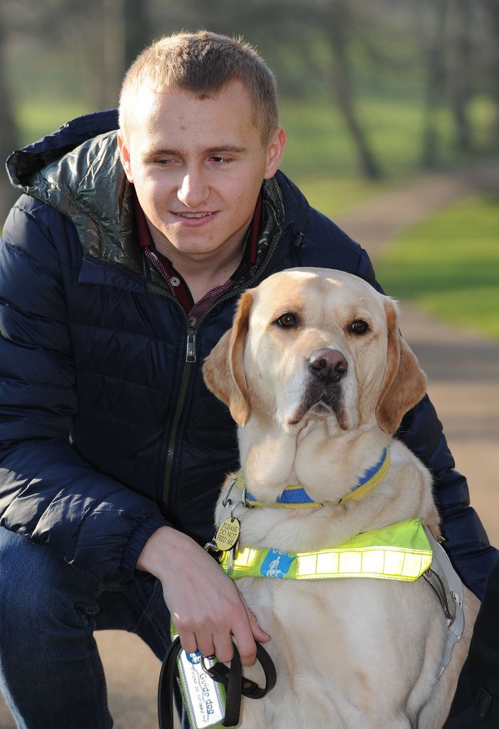 Nathan Edge, 22, from North Hykeham, Lincolnshire, with Hudson, his Labrador Retriever guide dog (Nick Ansell/PA Wire)