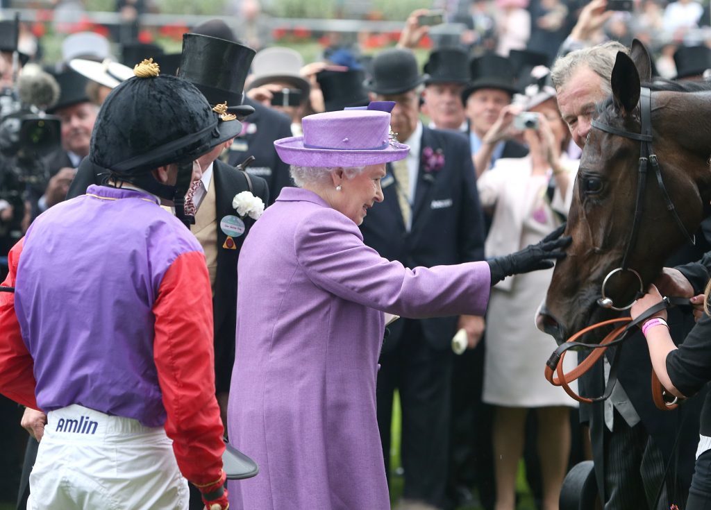 Queen Elizabeth II pats her horse Estimate after it won the Gold Cup ridden by jockey Ryan Moore (left) during Ladies' Day at Royal Ascot