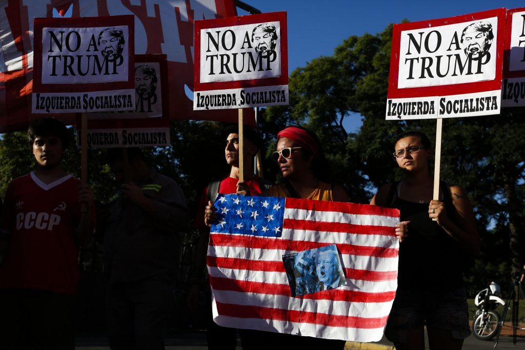 Dozens of protesters hold signs in front of the U.S. Embassy during a protest against the inauguration of President Donald Trump as the 45th President of the United States in Buenos Aires, Argentina, Friday, Jan. 20, 2017. (AP Photo/Agustin Marcarian)