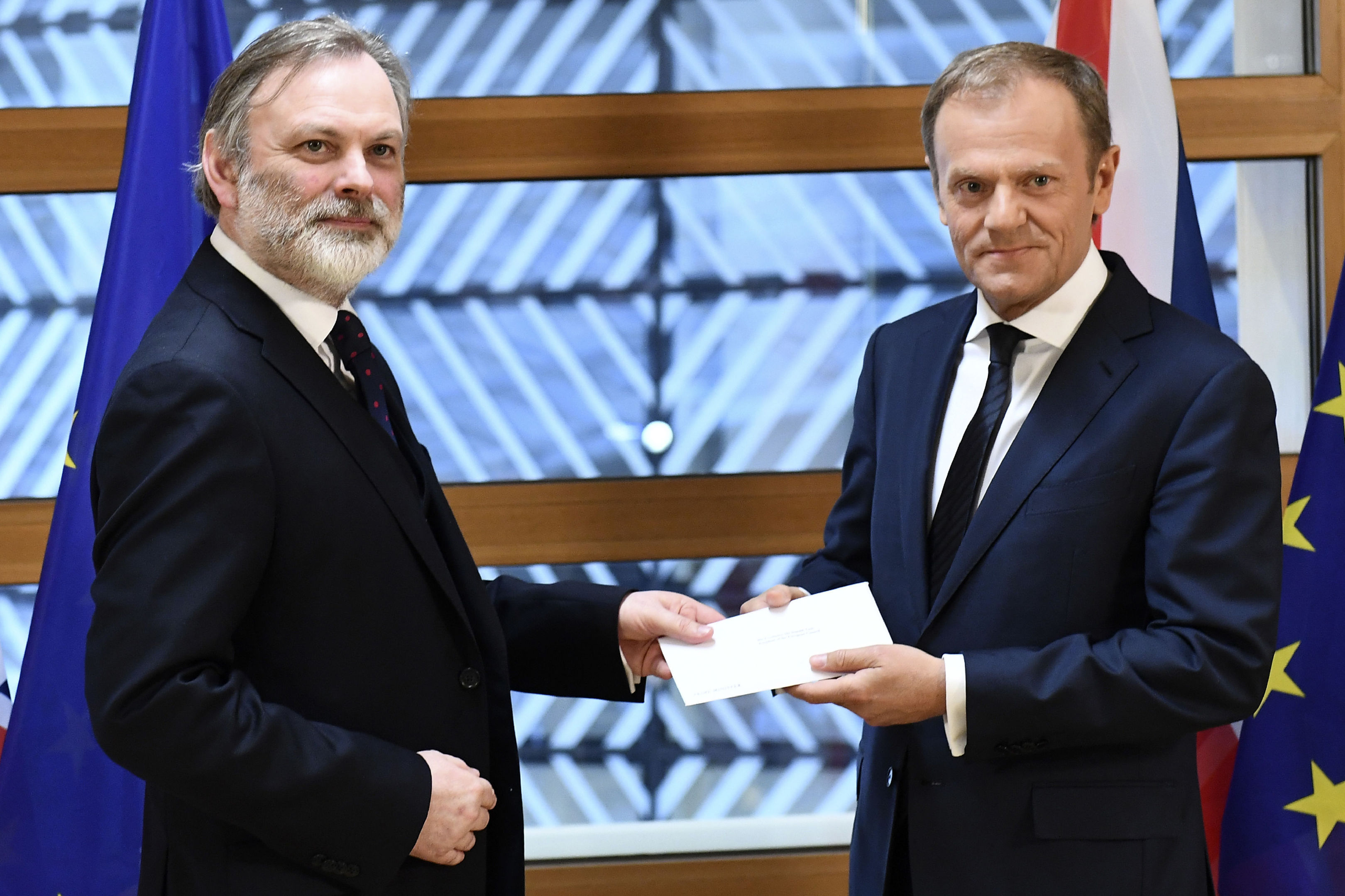 EU Council President Donald Tusk, right, gets Theresa May's formal notice to leave the bloc under Article 50 from UK Permanent Representative to the EU Tim Barrow (Emmanuel Dunand, Pool via AP)