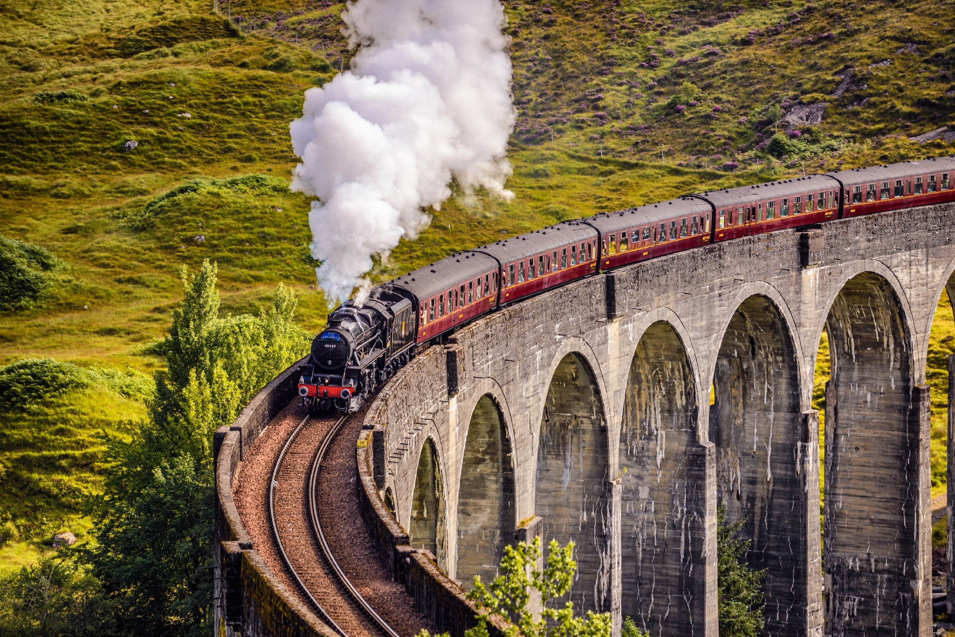 Glenfinnan Railway Viaduct in Scotland with the Jacobite steam train passing over on its way to Mallaig.