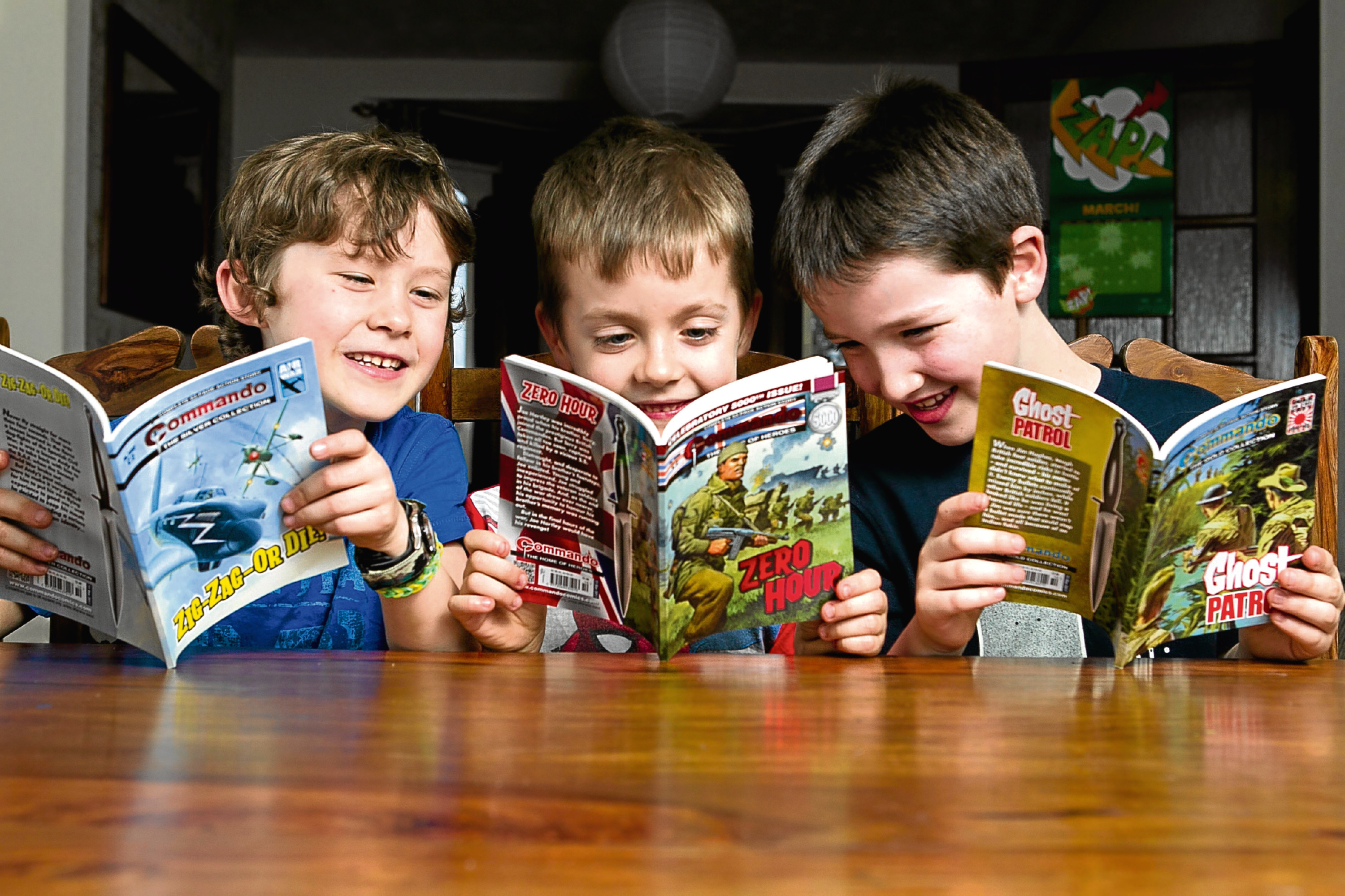 Bailey Dutton (8), Harry Gallagher (7), Evan Butler (7), reading 5000th edition of Commando (Andrew Cawley / DC Thomson)