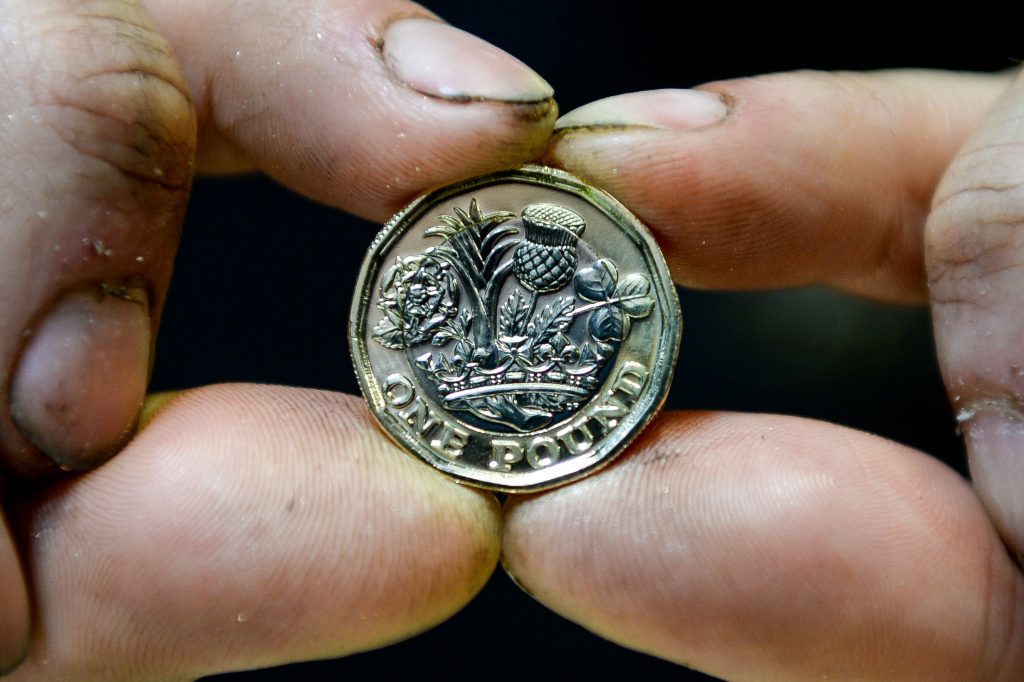 Editorial Use only Ð NO COMMERCIAL USE A 12-sided one pound coin in the hands of a Royal Mint Circulating Coin Press Setter at the Royal Mint in Llantrisant, Wales. PRESS ASSOCIATION Photo. Picture date: Tuesday March 14, 2017. The coins have started rolling off the production line at a rate of more than 4,000 a minute and will enter circulation later this month. It features a new design that shows a rose, a leek, a thistle and a shamrock emerging from one stem within a royal coronet. See PA story MONEY Pound. Photo credit should read: Ben Birchall/PA Wire