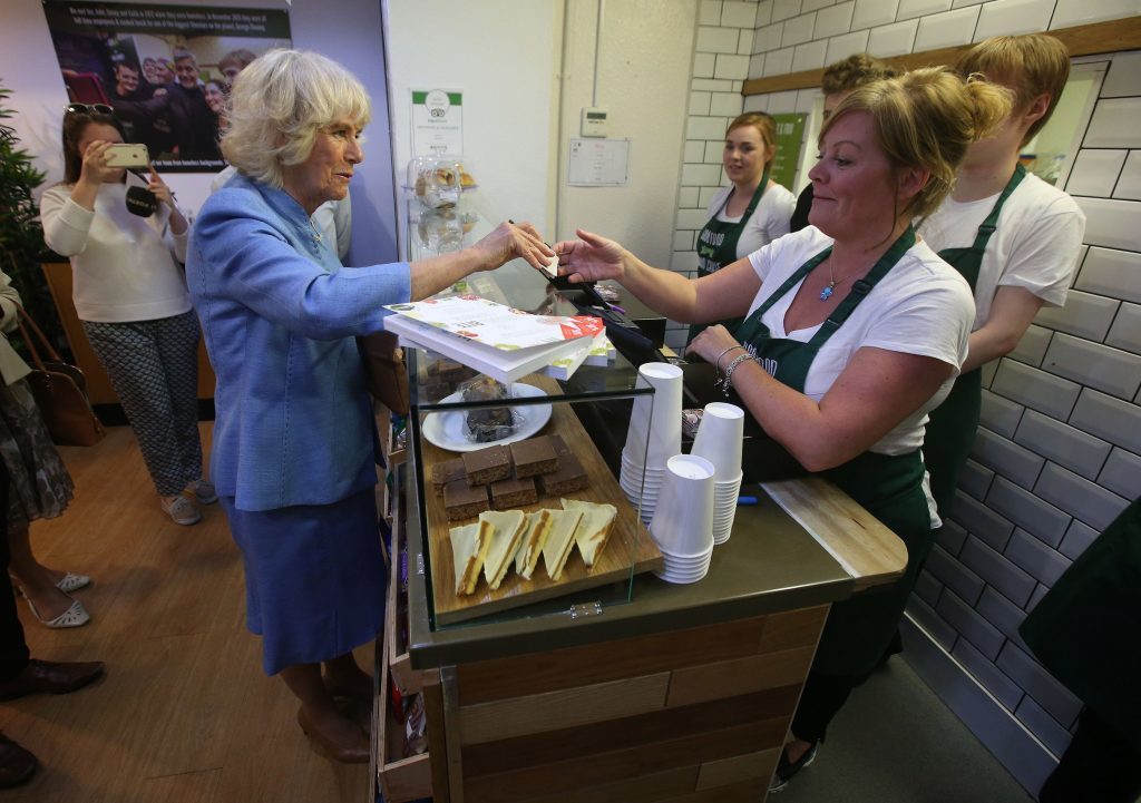 The Duchess of Cornwall, known as the Duchess of Rothesay while in Scotland, speaks to Bonnie Burton (right) as she donates money, during a visit to Social Bite (PA)
