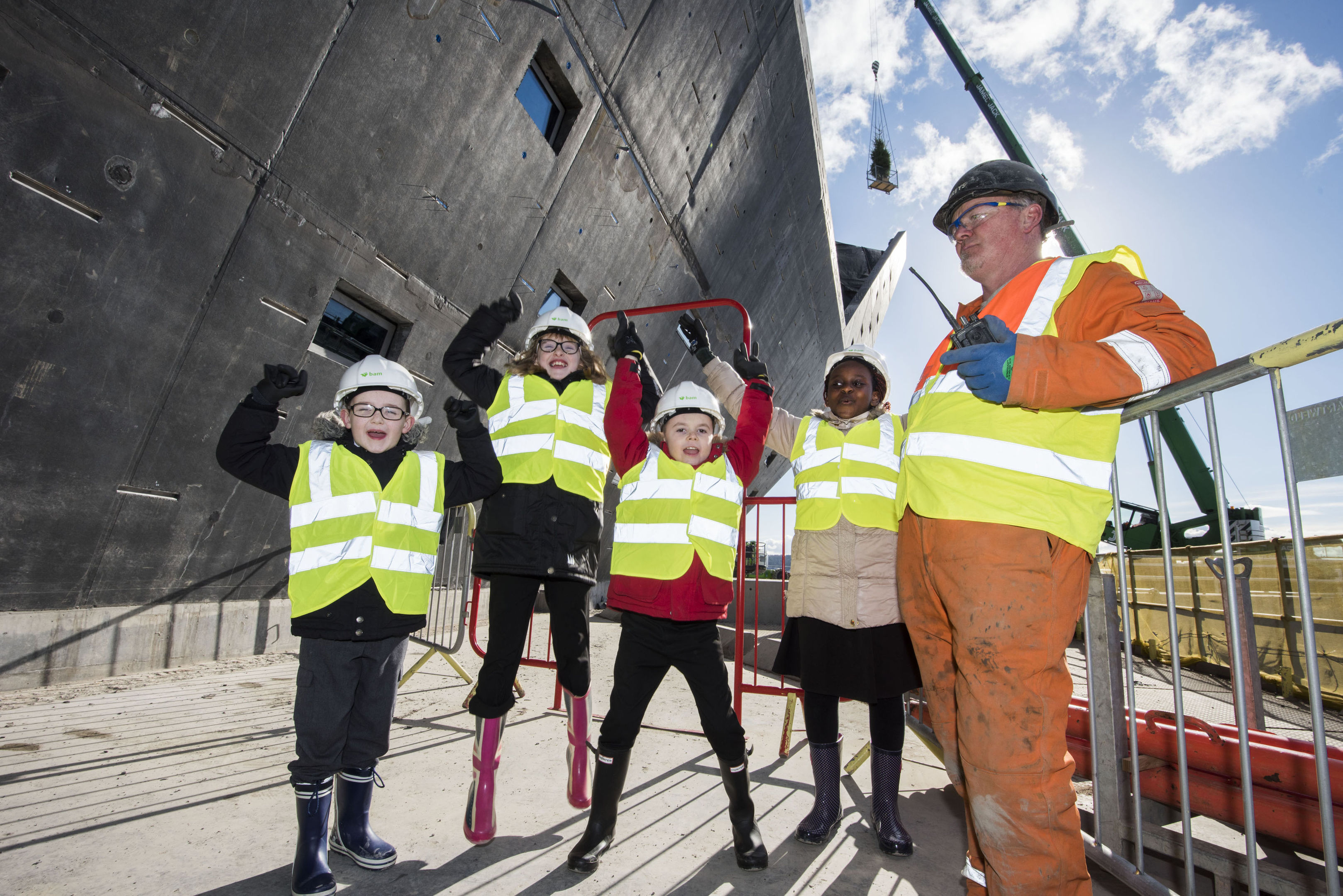 Site foreman Sean McGee and local school pupils (left to right) Dominic Nelson, Sarah McGillivary, Jak Adams and Fiona Okeke celebrating as a crane driver positions a Douglas Fir tree at the highest point of the building during the topping-out ceremony for the V&A Museum of Design Dundee. (Alan Richardson/PA Wire)