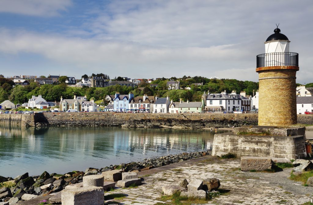 View of the lighthouse and harbour lined with colourful houses at Portpatrick in southwest Scotland on a summers day (iStock)